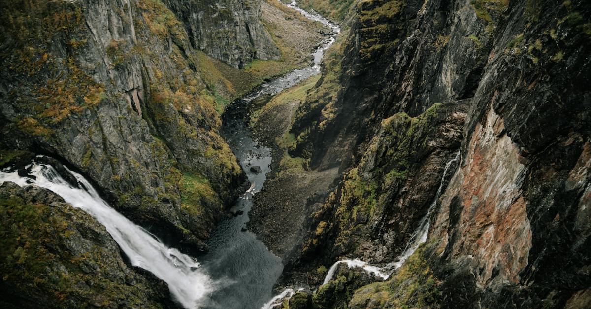 from above of powerful waterfall falling from rocky cliff in mountainous ravine in highland